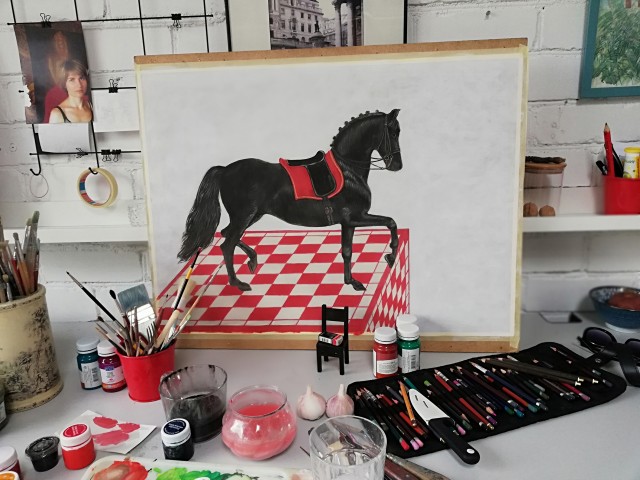 Juodas žirgas ant raudonos šachmatų lentos